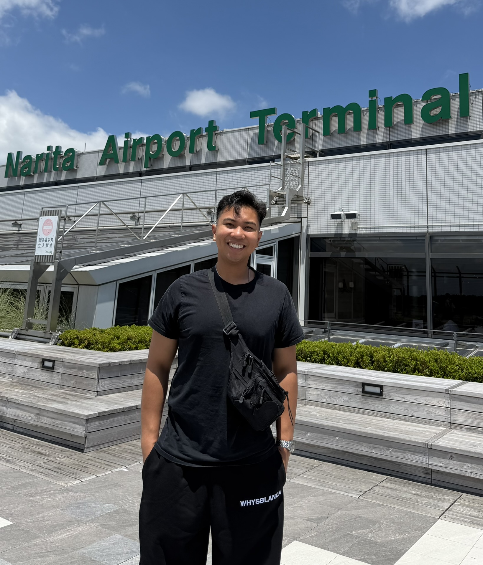 Josh smiling outside Narita Airport Terminal in Japan
